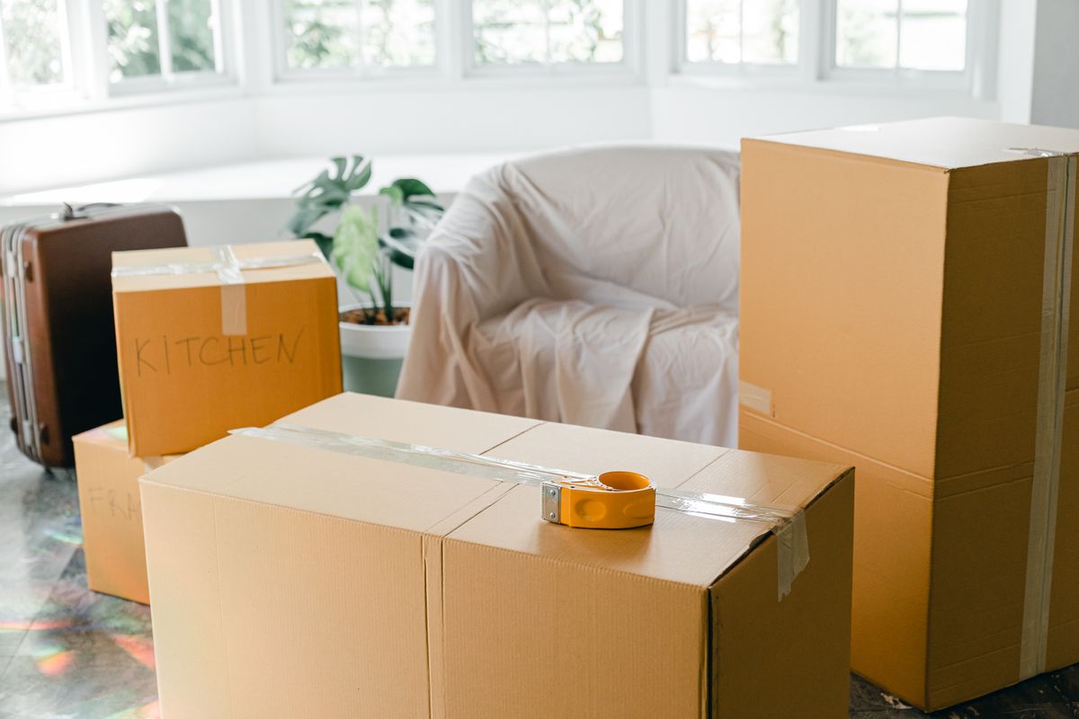 Packed boxes and a suitcase in a bright apartment.