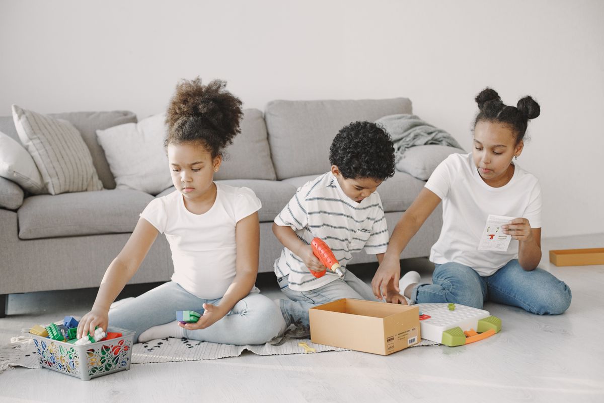 Children playing with small toys on a living-room floor.