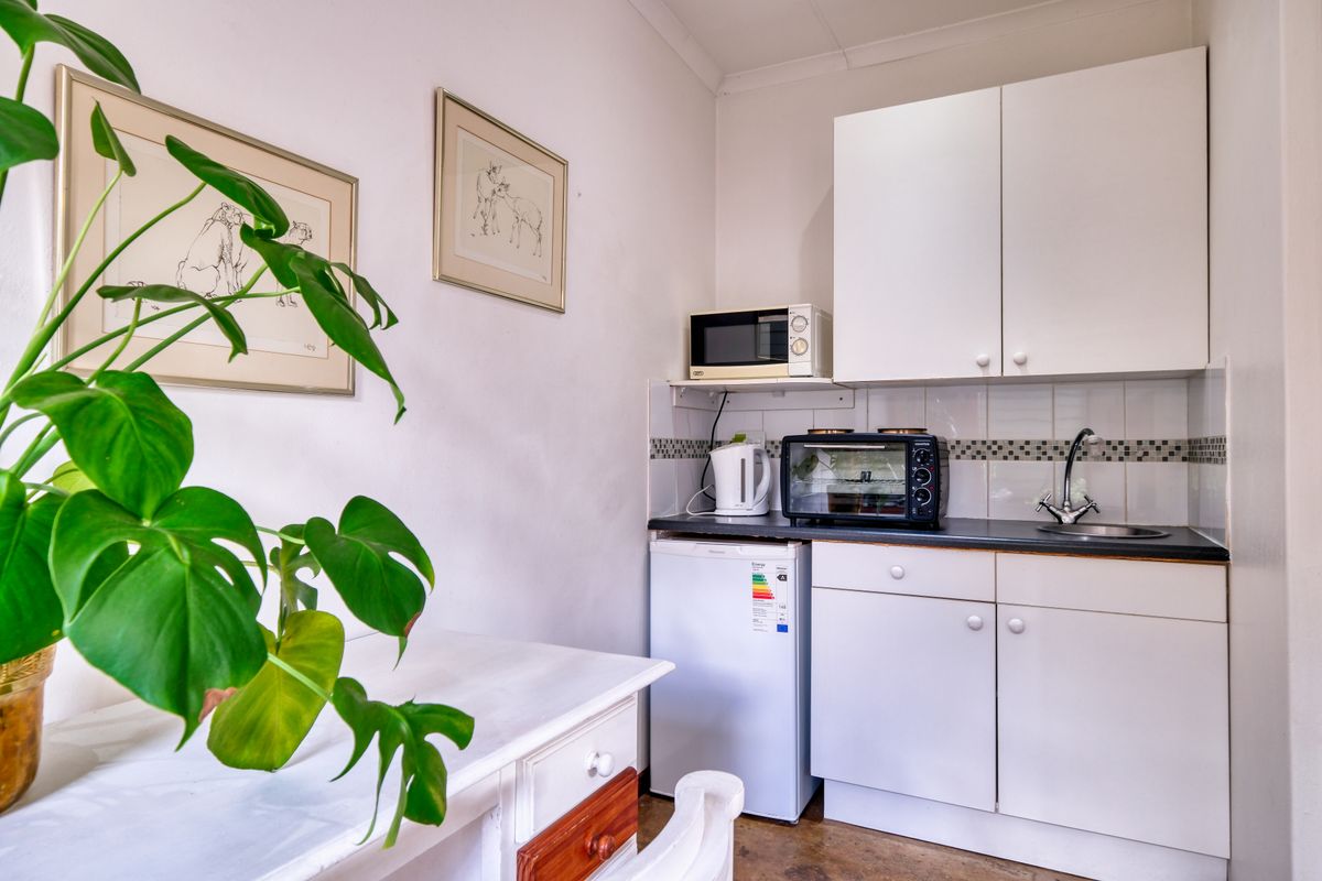 A compact kitchenette with a small fridge and microwave.