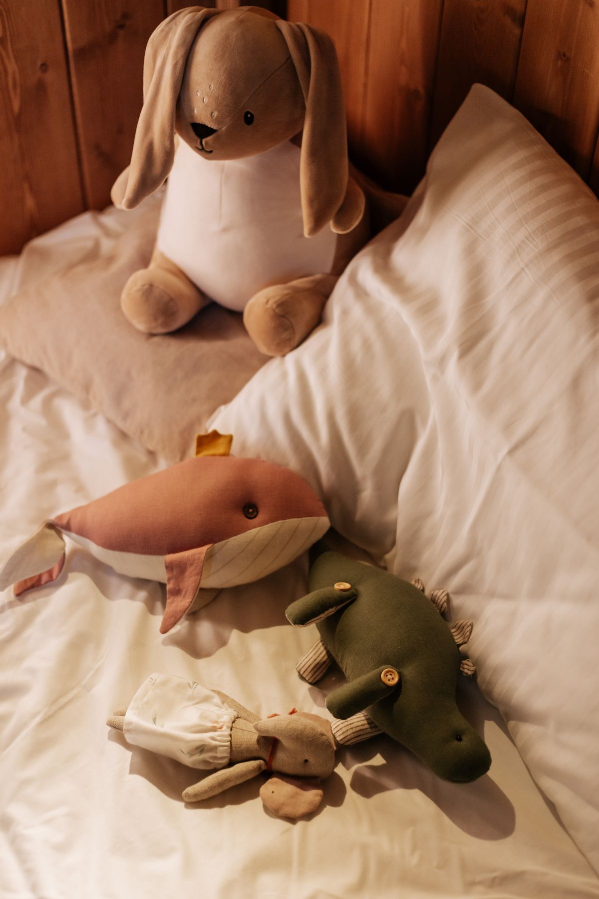Soft toys arranged on a child's bed.