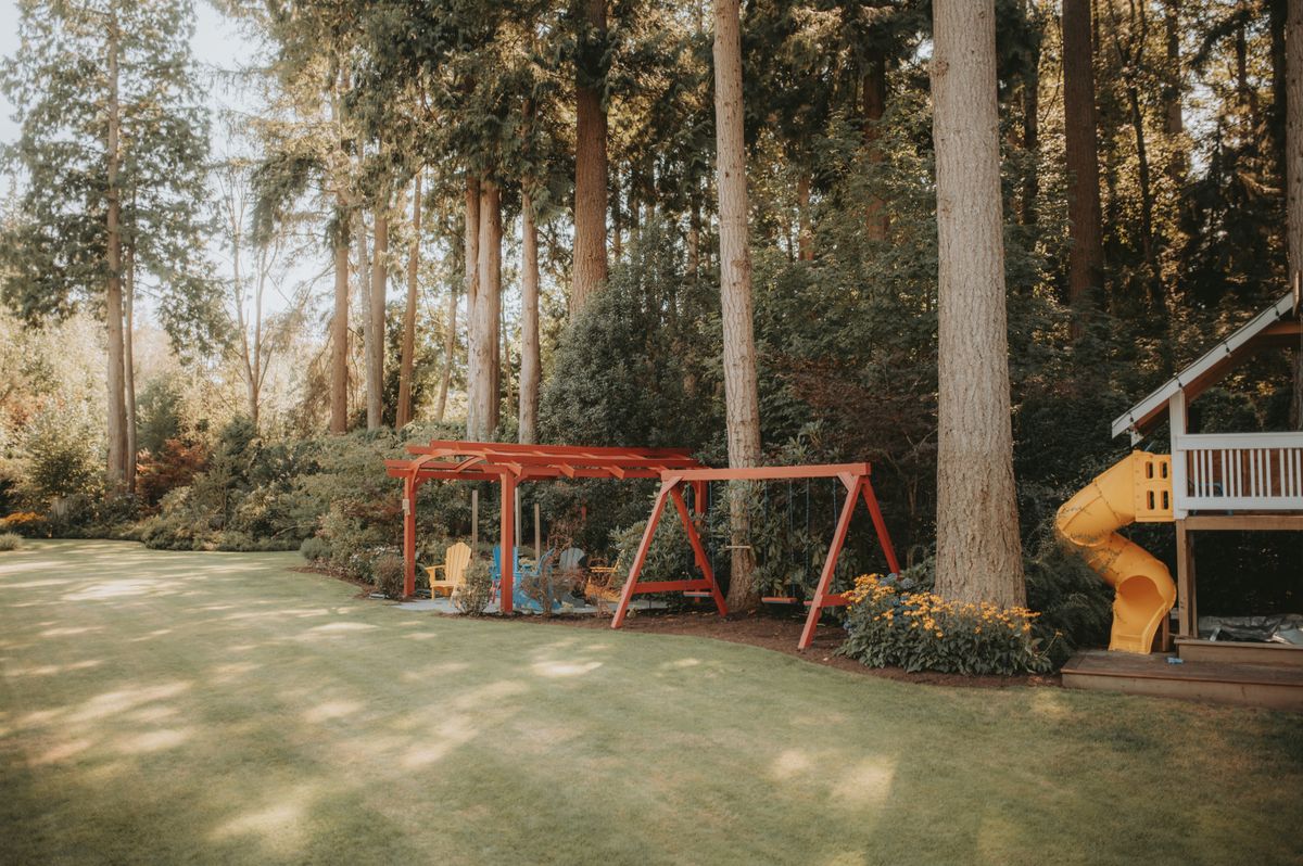 Slides and swings in a green outdoor playground.