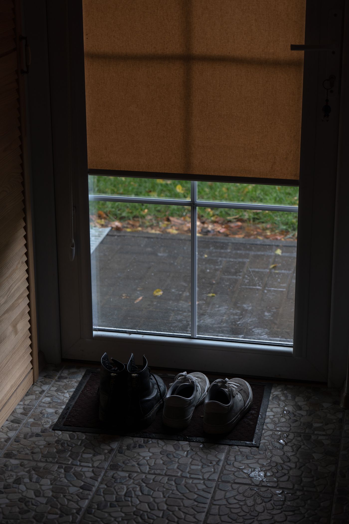 Shoes arranged beside a household doorway
