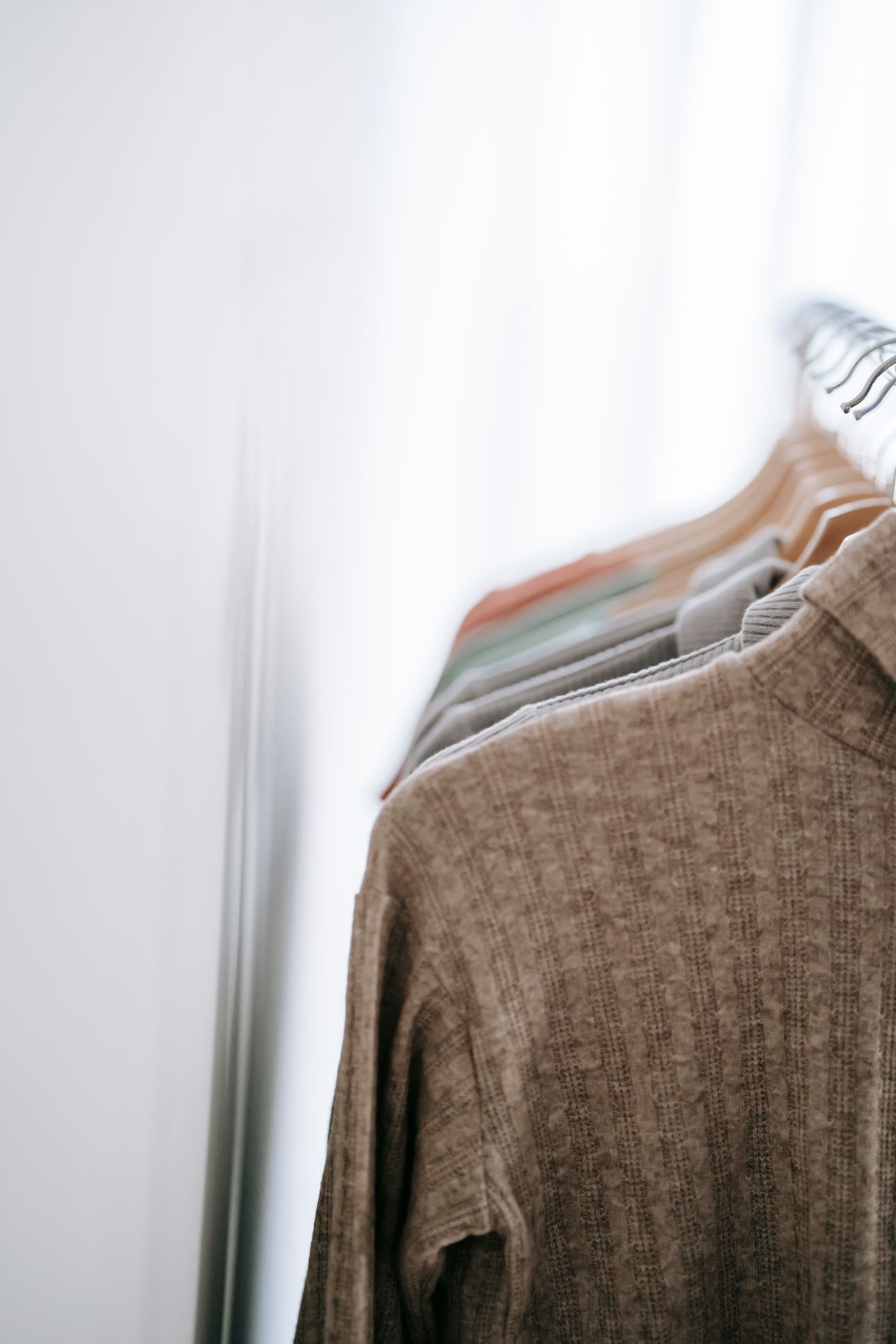 Sweaters hanging together on a clothing rack
