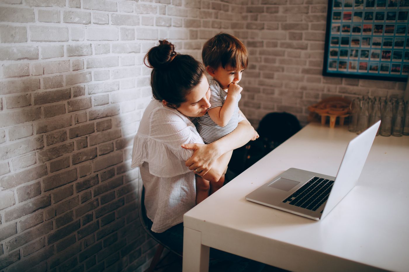 A mother and child making a video call on a laptop