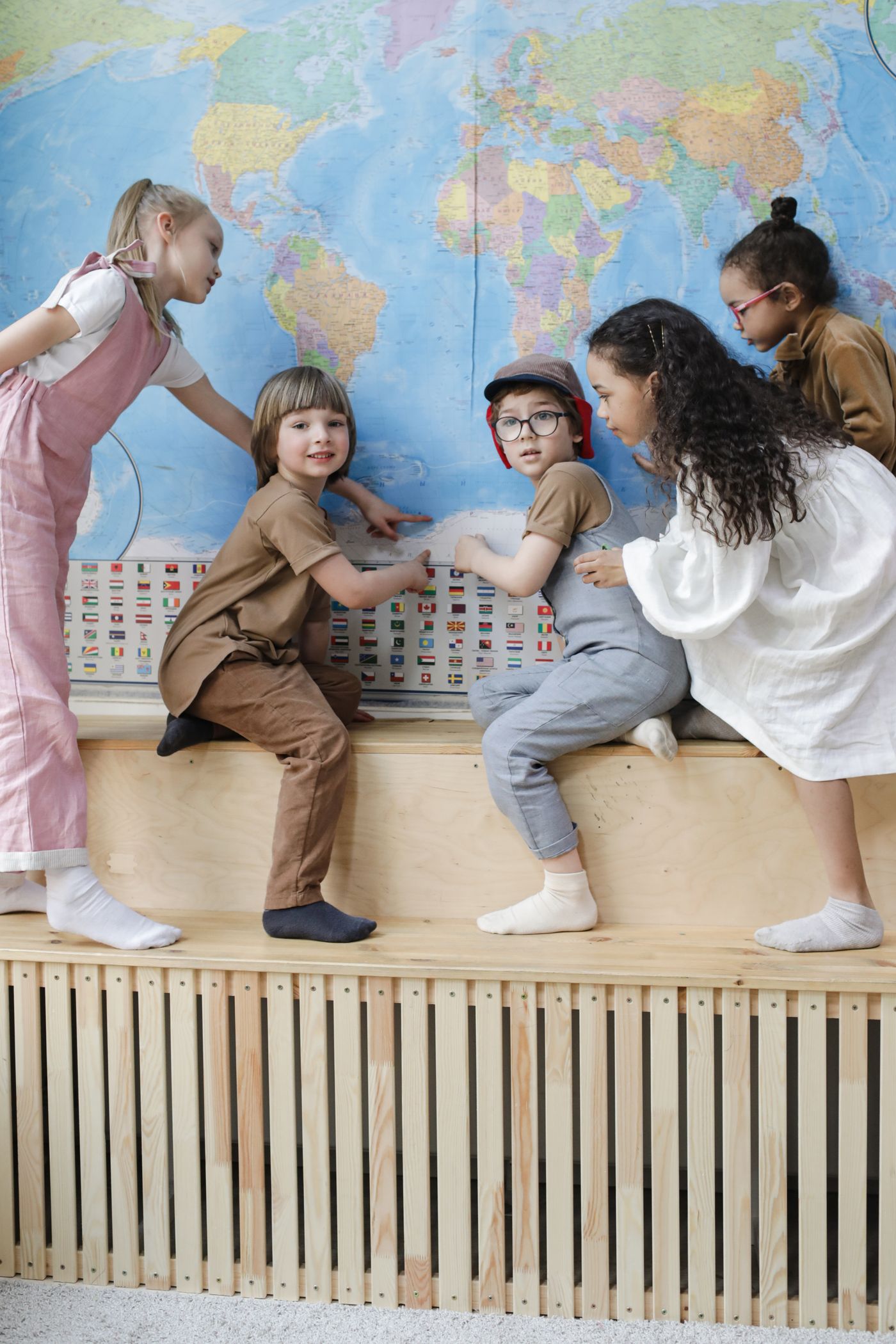Children pointing to places on a wall map