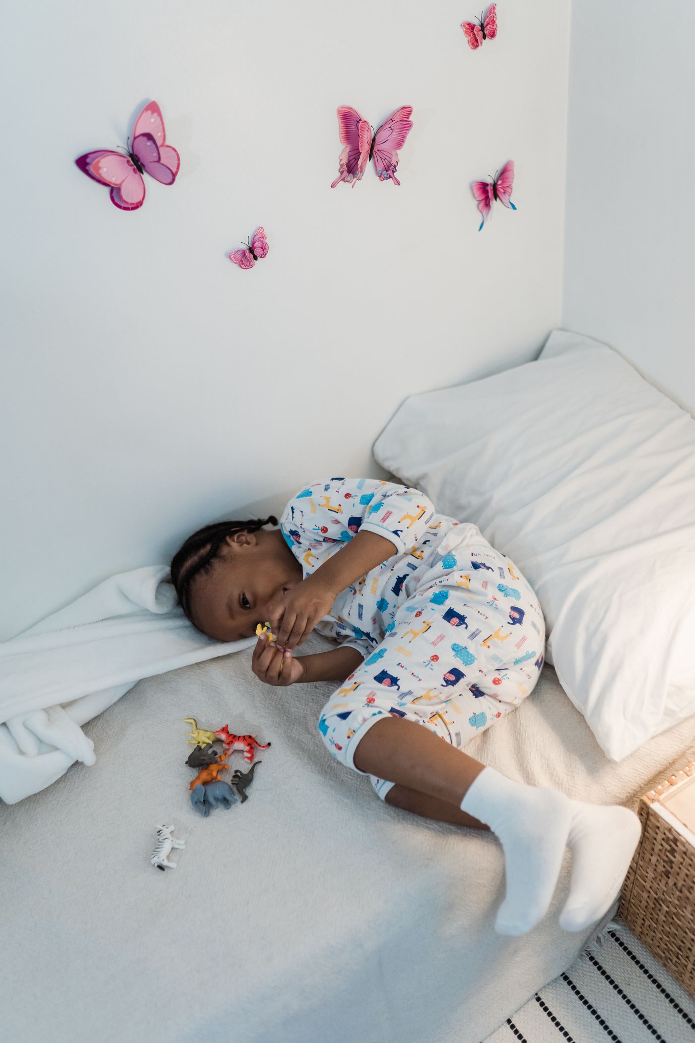 A child relaxing on a bed with soft toys