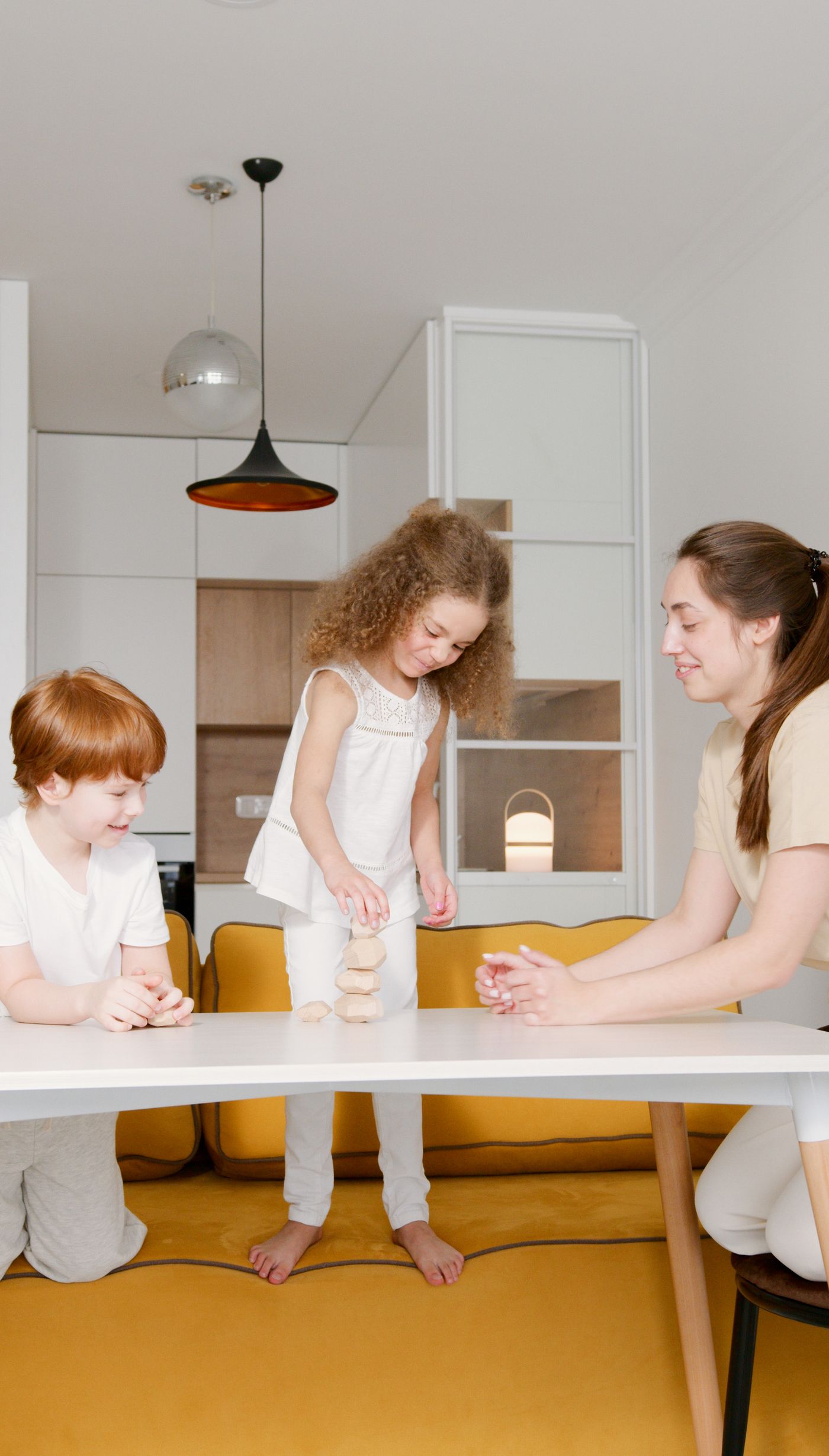 A mother and two children sharing a table game