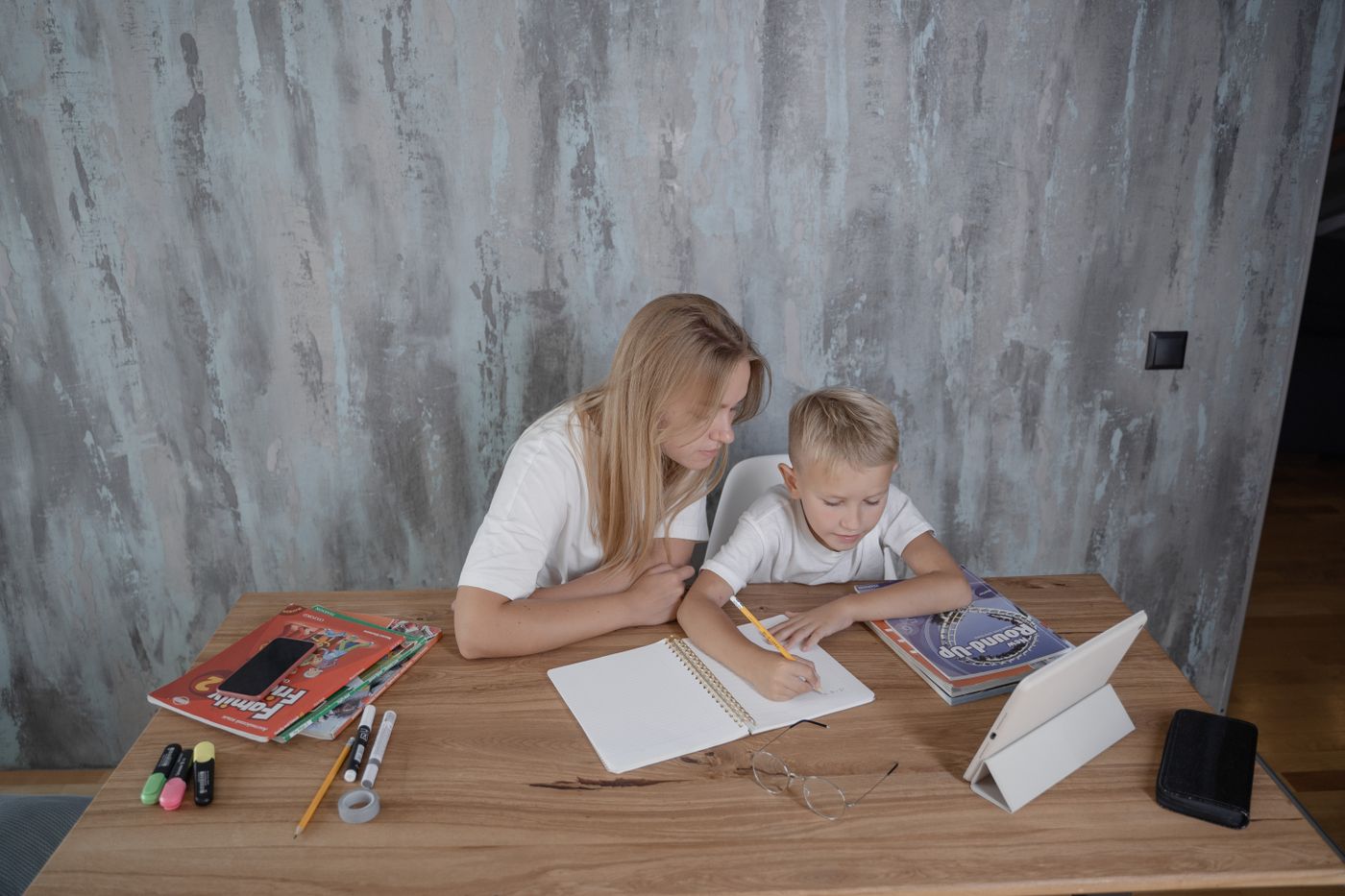 A parent helping a child with work at a desk