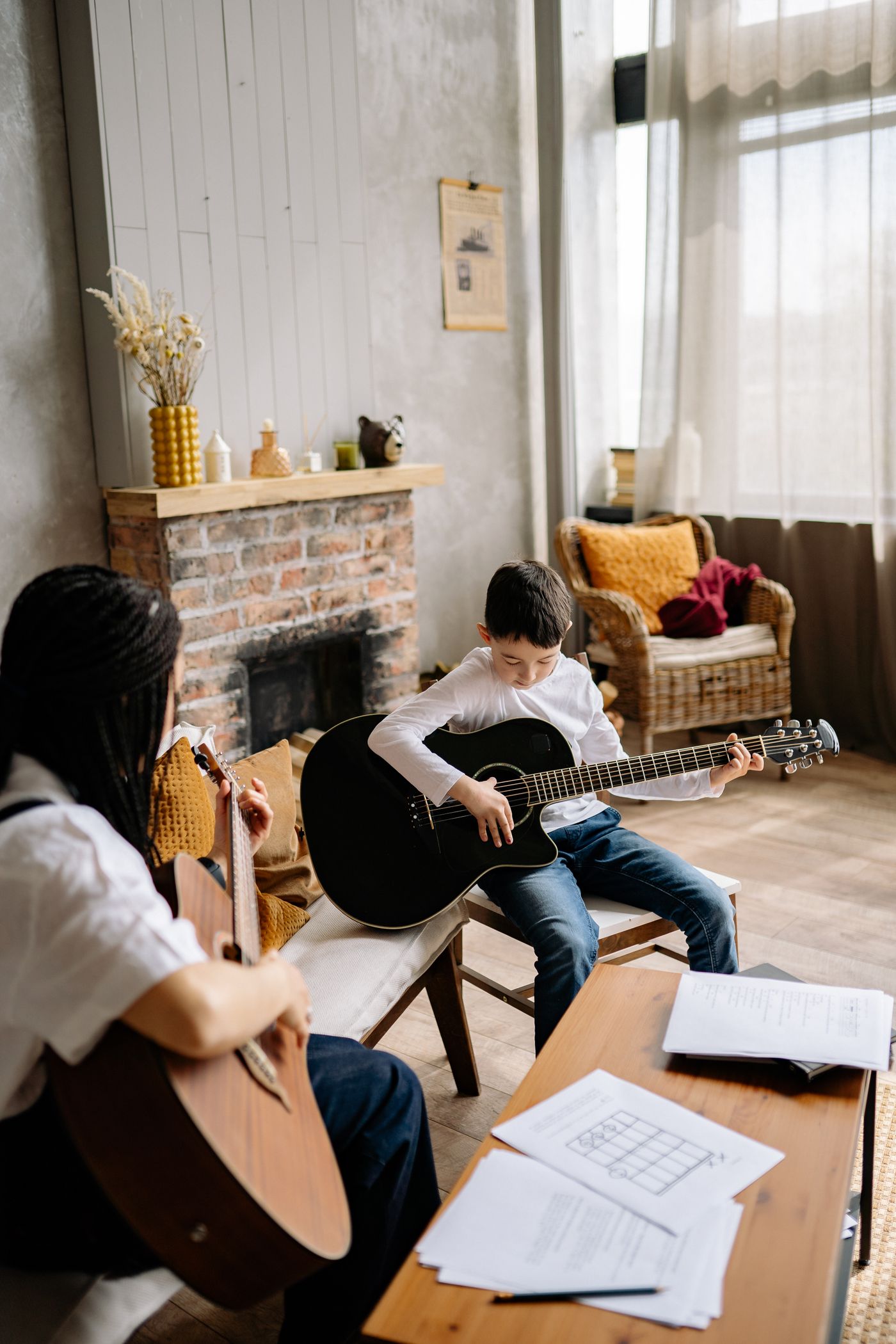 An adult and child holding guitars during a lesson