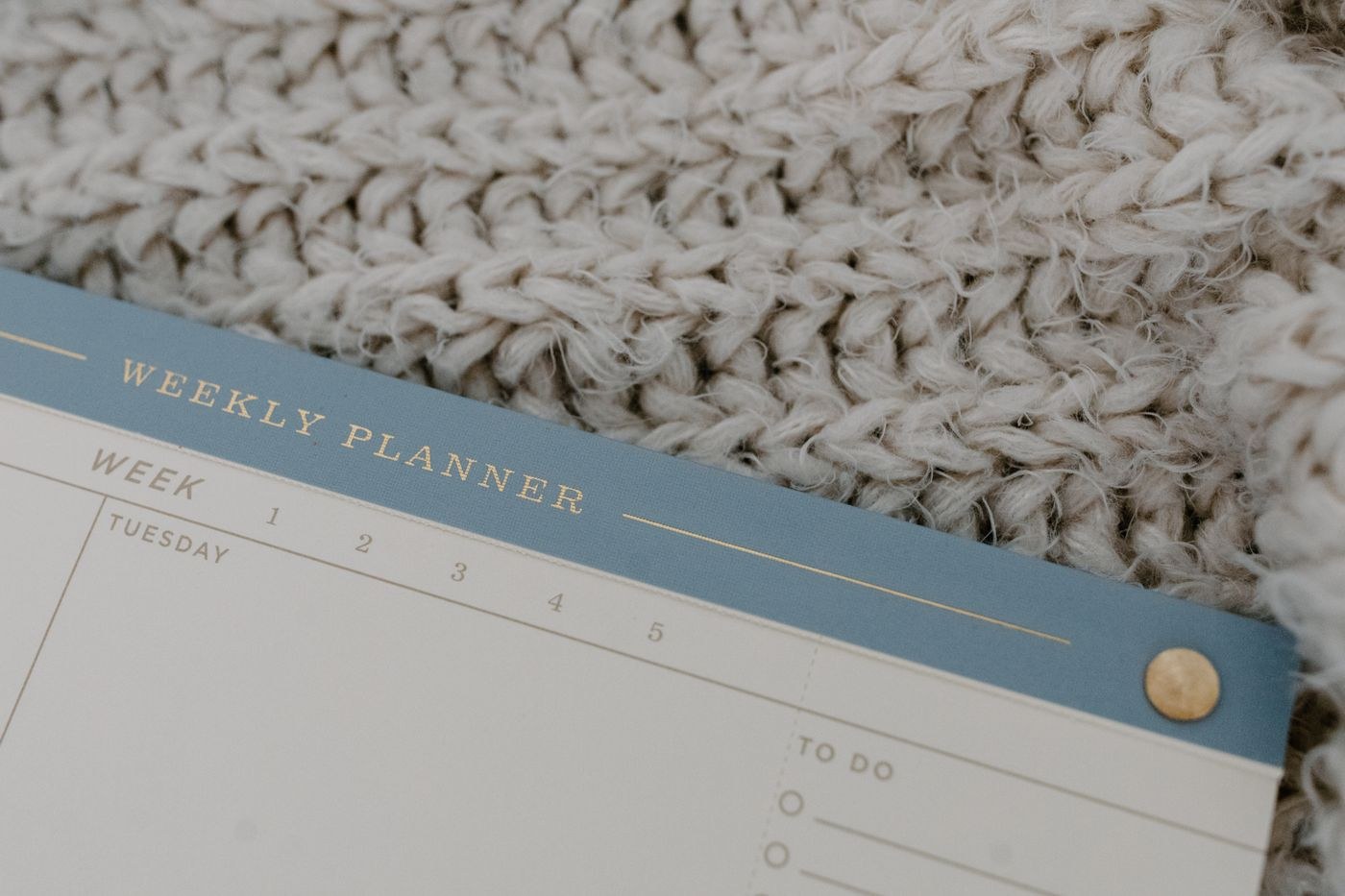 An open weekly planner on knitted fabric
