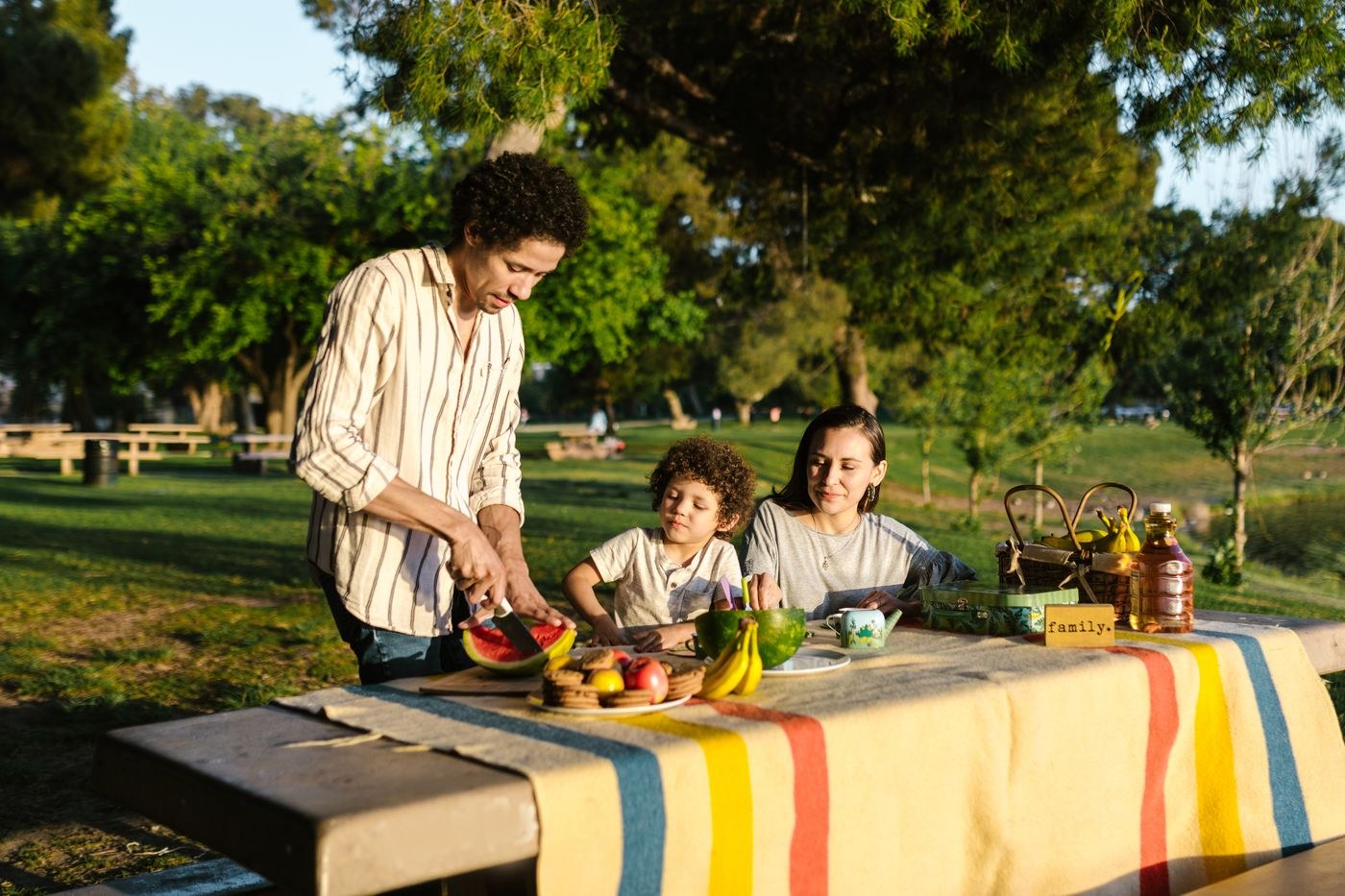 Adults and a child sharing food at a picnic table
